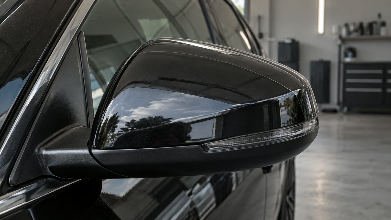Curva da capa de um retrovisor preto sob luz natural.